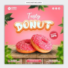 two donuts with sprinkles sitting on top of a wooden table in front of a pink background