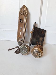 two antique door knobs with keys on them