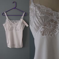 "vintage pretty romantic cropped baby doll camisole tank top in porcelain white color. delicate floral lace top front. adjustable shoulder straps. circa 1980s made by Shadowline intimate apparel will best fit small, medium: 38\" bust 34\" waist 24\" length 11\" straps condition: excellent!" Lace Camisole Top In Flirty Style, Lace Coquette Camisole Top, Coquette Lace Camisole Top, Coquette Tops With Lace Trim And Spaghetti Straps, Vintage White Lace Trim Camisole, Vintage White Camisole With Lace Trim, Vintage Delicate Lace Camisole With Spaghetti Straps, Vintage Lace Trim Camisole Tank Top, Vintage Lace Trim Tank Top