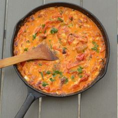 a skillet filled with food on top of a wooden table