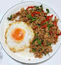 an egg on top of rice with meat and vegetables