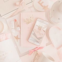 a pink phone sitting on top of a table next to other accessories and items that include lipstick