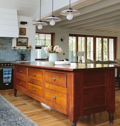 a large kitchen with wooden cabinets and an island in front of the stove top oven