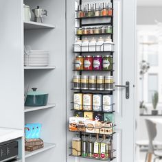 the pantry door is open to reveal an assortment of spices and condiments on shelves