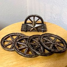 three metal wheels are sitting on a wooden table next to a star shaped trinket