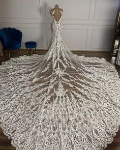 a wedding dress is displayed on a mannequin in front of a white wall