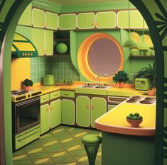 a green and yellow kitchen with an archway leading to the dining room, which has potted plants on the counter