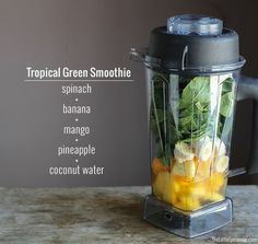 a blender filled with fruit and vegetables on top of a wooden table