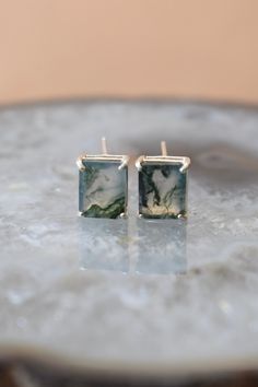 ------------------------------------------------------- Moss Agate Earrings THE PRODUCT - These are stunning moss agate earring in the classic emerald cut. - Since it's a natural moss agate the beautiful green will vary per piece and have some amazing imperfections that remind you that this is truly a piece of the earth. - We select each stone individually so even though each piece may vary slightly. - The moss agate is cushion cut to show off all of its imperfections and different tones and the Dyi Earrings, Emerald Cut Earrings, Moss Agate Jewelry, Simple Woman, Green Moss Agate, All The Small Things, Cut Earrings, Plastic Earrings, Agate Earrings