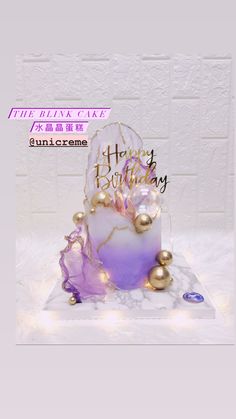 a purple and white birthday cake with gold decorations