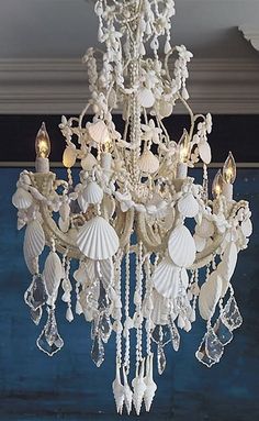 a chandelier hanging from the ceiling with shells and seashells on it