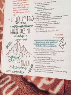 an open bible with the words i lift my eyes and mountains written in green ink