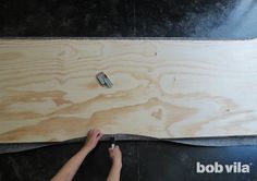 a person is working on a piece of plywood that has been cut into pieces