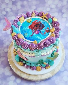 there is a cake decorated with mermaids and seashells