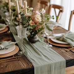 the table is set with plates, silverware and green napkins for an elegant look