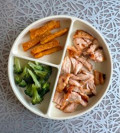 a plate with broccoli, carrots and meat in it on a table