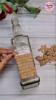 a bottle filled with small pieces of wood sitting on top of a table