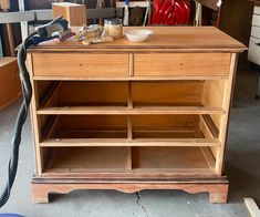 a wooden cabinet with drawers and tools on it