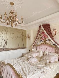 a bedroom with a bed, chandelier and paintings on the wall