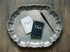 two notebooks sitting on top of a metal plate