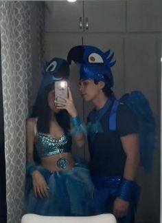 a man and woman dressed up in costumes taking a selfie with a cell phone