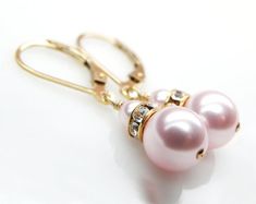 Simple and elegant Swarovski pearl earrings in a sweet soft pink hue. Accented with gold Swarovski crystal rhinestone crowns. Handmade with 14k gold filled wire and leverback earring closures (ones which clasp on the back). Short drop earrings are the perfect accessory for weddings, dress up events, and everyday. Makes for a sweet gift for your bridal party on your wedding day. A great feminine gift for women who love pink and gold jewelry.Earrings Details:- Earrings are 1.25 inches (3.17 cm) lo Classic Pink Earrings For Wedding, Elegant Pink Bridal Earrings For Gifts, Elegant Pink Pearl Earrings For Anniversary, Elegant Pink Bridal Earrings As Gift, Pink Pearl Drop Earrings As Gift, Elegant Round Pink Bridal Earrings, Classic Pink Pearl Earrings For Wedding, Pink Pearl Bridal Earrings As Gift, Pink Pearl Earrings For Wedding