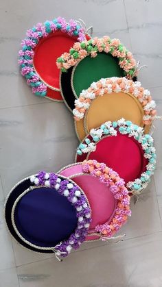 several different colors of hats are on the floor with beaded trims and beads