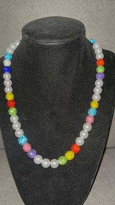 Grab this customRainbow color themed Baseball Pearl beaded necklace with pops of color throughout.  Red Green Yellow Blue Rhinestone Beads Wear it just like the pros! 20 inch w/ magnetic clasp for ease and comfort. (request for longer/shorter) Elevate your style AND your game with our vibrant, handcrafted beaded necklace.   🌟 Features: 🌟 Unique Design 💎 Quality Matters: Thick Elastic band and screw clasp ensure durability and long-lasting wear. 🌟 Versatile Wear: Perfect for all sports fields😎, beach days, date nights, or simply adding a pop of personality to your everyday look. A conversation piece. 📸 Instagram-Ready: Be prepared for compliments and photo ops wherever you go! Follow DingerCityDrip on IG Black Silver White Cross Beaded Necklace Fruit Loop Phillies Yellow Orange Green Jose Alvarado, Rainbow Pearl, Fruit Loops, White Cross, White Crosses, Bead Chain, Red Green Yellow, Rhinestone Bead, Red Blue Green