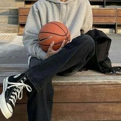 a man sitting on a bench holding a basketball