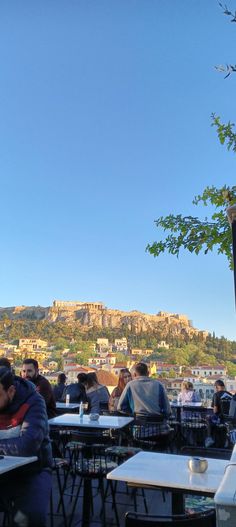 people are sitting at tables in front of the acrobatic hill