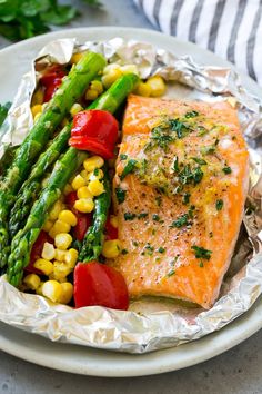 grilled salmon and asparagus on foil with tomatoes, corn and green beans