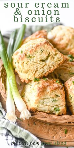 some scones are sitting in a wicker basket on a table with green onions