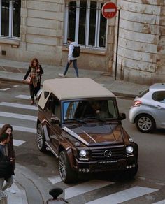 people crossing the street in front of an suv