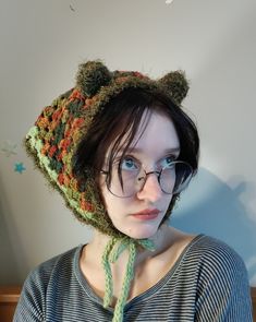 a woman wearing glasses and a knitted bear hat