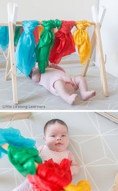 a baby laying on its back in front of some colorful ribbons