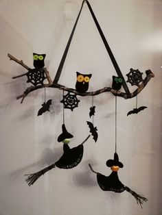 a group of owls sitting on top of a tree branch with bats hanging from it