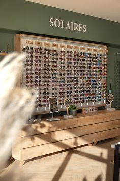 a display case with many pairs of sunglasses on it's sides and the words solaires above them