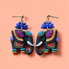 the earrings are decorated with flowers and an elephant