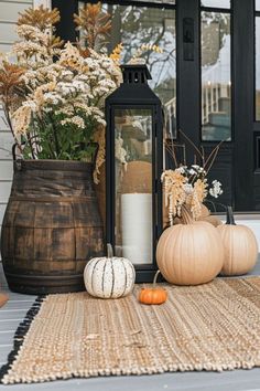 pumpkins and gourds are sitting on the front porch for fall decorating