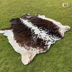 a cowhide rug is laying on the grass