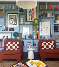 a living room filled with furniture and bookshelves covered in pictures on the walls