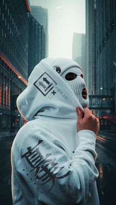 a person wearing a white hoodie and covering his face with a mask in the city