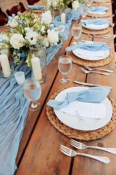 the table is set with blue linens and place settings