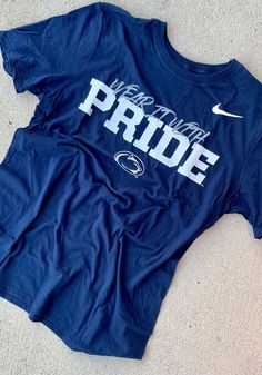 Show off your team pride in this Penn State Nittany Lions Navy Blue Mantra Short Sleeve T Shirt! This Penn State Short Sleeve Tee features a screen print of Wear It With Pride over Penn St logo. Make sure everyone knows you root for the Nittany Lions with this Navy Blue Penn State T Shirt. Go Lions! Dri-Fit Cotton, Screen printed team specific local verbiage in generic team font, Team logo/name lockup printed below, Swoosh design trademark on left shoulder, Fit: True to Size, 57% COTTON/ 43% POL Mantra Design, St Logo, Lion Tshirt, Nittany Lion, Penn State, Short Sleeve T Shirt, Screen Print, Mantra, Team Logo