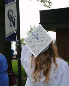 a woman wearing a white graduation cap with writing on the front and back of her hat