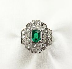 "Circa 1930. Art Deco Gorgeousness. A very lovely green indeed. A prong set, mixed cushion cut 0.45ctw emerald is accented by 24 sparkling bead set round single cut diamonds in a linear art deco platinum setting. I love how the central rectangle step sits slightly above the tapering side steps which gives a nice dimension to the setting. The bit of negative space, which I think is often under appreciated in deco rings, is such a great design detail. After all, the setting is the foundation of be Diamond Ring Price, 1930 Art, Deco Rings, Art Deco Emerald Ring, Linear Art, Emerald And Diamond Ring, Edwardian Jewelry, Amethyst And Diamond Ring, Art Deco Diamond Rings