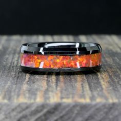 a ring with an orange and black opalite inlay on top of it