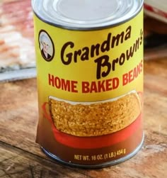 a can of grandma brown's home baked beans sits on a wooden table top