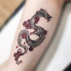 a dragon tattoo on the arm with flowers around it and an inscription that reads, tattoo ideas