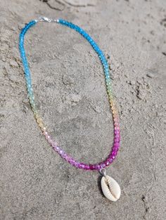 Our Tropical Shell Chokers Indulge in the essence of paradise with every wear! This Shell Choker brings a touch of tropical beauty to any outfit, making you feel like you're lounging on a remote island. Handcrafted with genuine shells, each choker is unique and radiates a luxurious, beachy vibe. Elevate your style and transport yourself to a beach getaway every time you put on this statement piece! Strung on durable jewelry cord, this Shell choker is adorned with rainbow faceted glass beads and a cowrie shell as the focal point and a sterling silver closure. These necklaces can be worn alone or stacked for a laid-back, tropical beachy feel. Dimensions: measuring 16 inches around (rainbow variations may vary) Add this one-of-a-kind necklace to your cart today and bring a touch of the ocean Summer Festival Shell Strand Necklace, Multicolor Strand Shell Necklace For Vacation, Colorful Beads Shell Strand Necklace For Beach, Handmade Multicolor Shell Necklace For Beach, Beachy Shell Necklace With Colorful Beads For Vacation, Colorful Beaded Strand Shell Necklace For Beach, Multicolor Handmade Shell Necklace For Beach, Multicolor Shell-shaped Jewelry For Beach, Multicolor Strand Shell Necklace For Beach